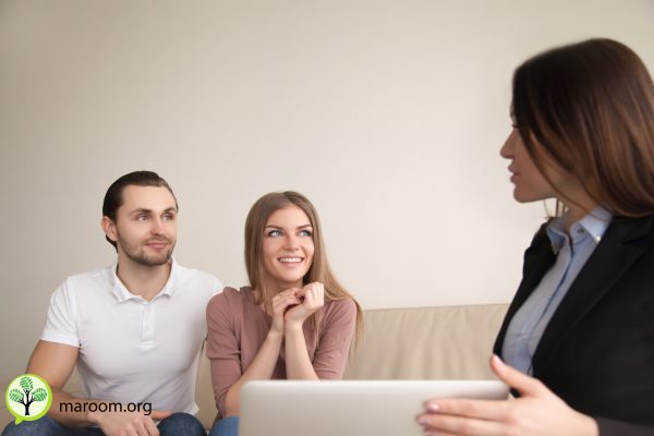 Smiling couple discussing future vacation with travel agent, man and woman planning real estate purchase consulting with broker, female agent explaining attractive mortgage offer to young happy family